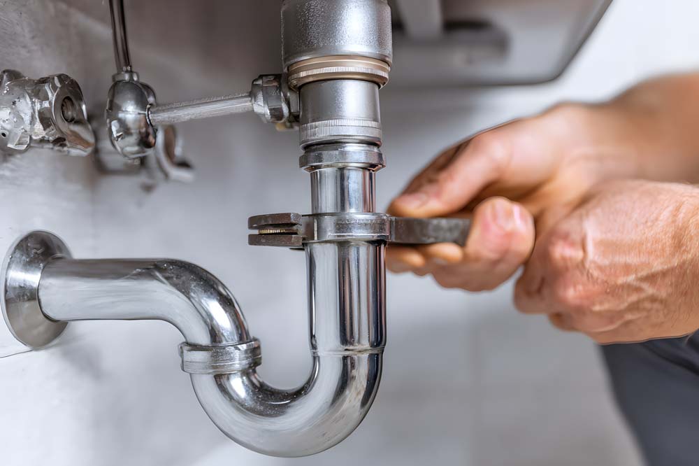 pipe being tightened by a plumber