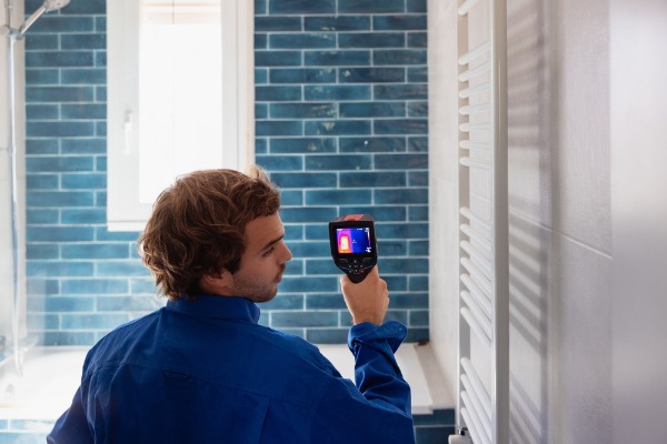 plumber using thermal camera in bathroom